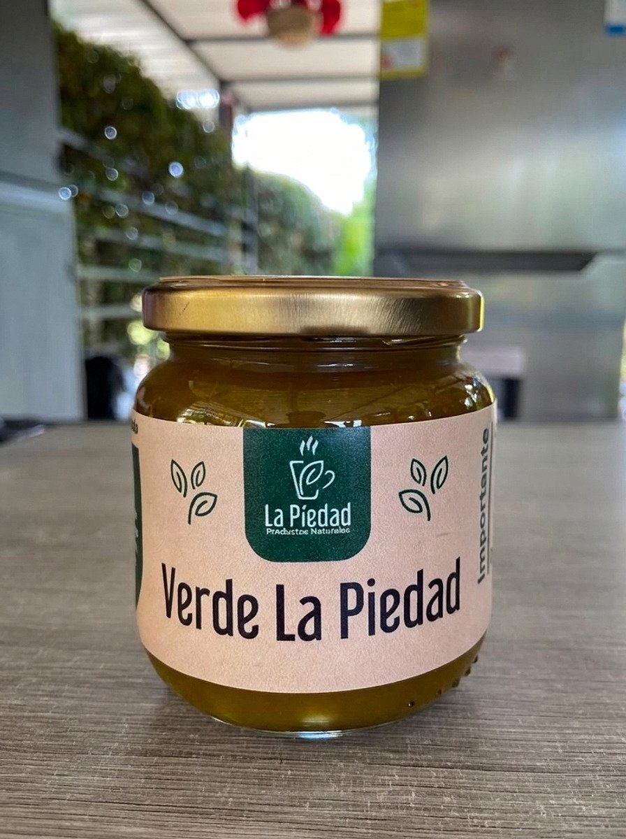 Frasco de Verde La Piedad de 250 gramos, de etiqueta crema, sobre el mesón del punto en Guarne.